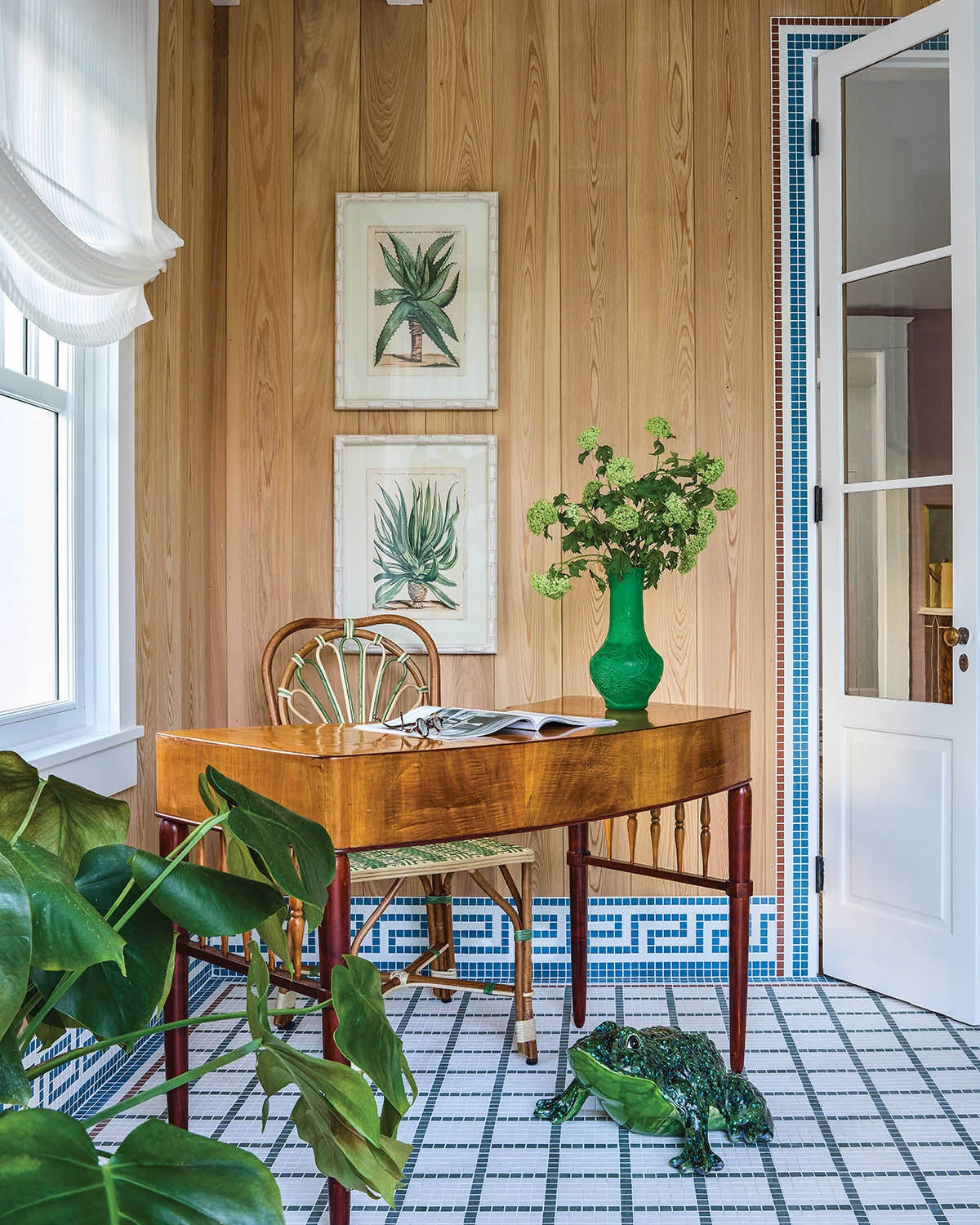 An antique desk from F.S. Henemader Antiques sits against walls trimmed in a jaunty Greek key motif, giving the Florida Room a dash of classical attitude.